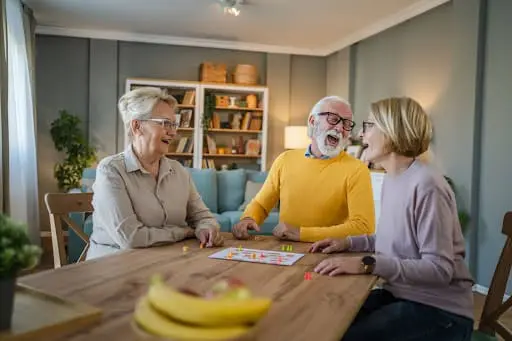 seniors playing board games in living room seniors playing board games in living room