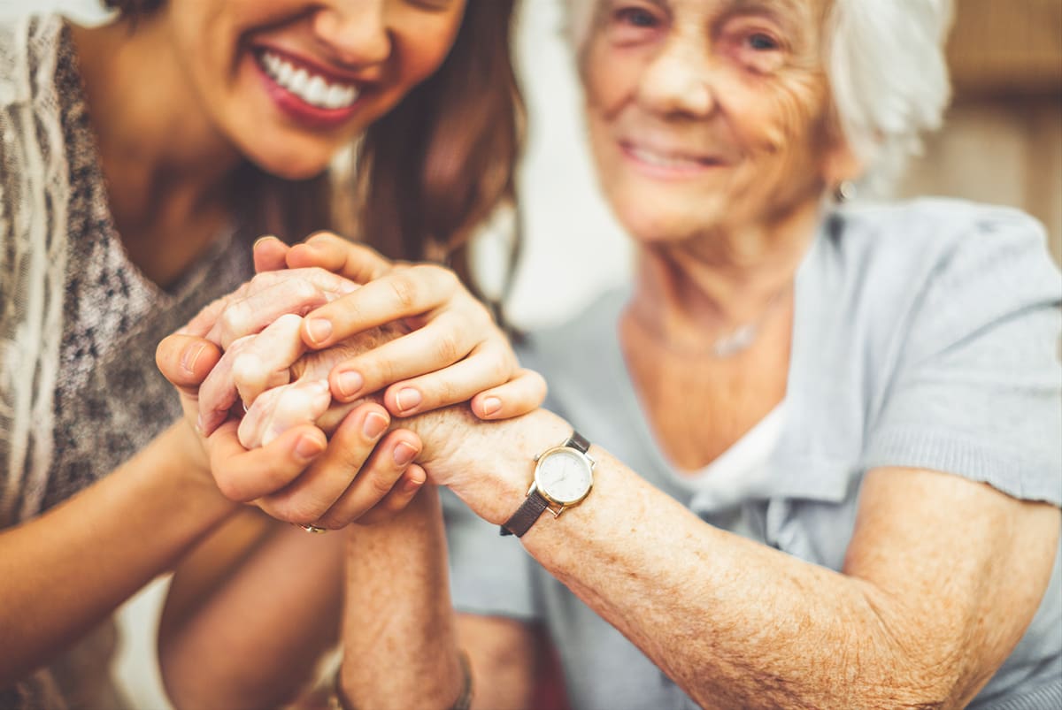 Mar_1_Heartfelt A woman holds the hands of her elderly mother