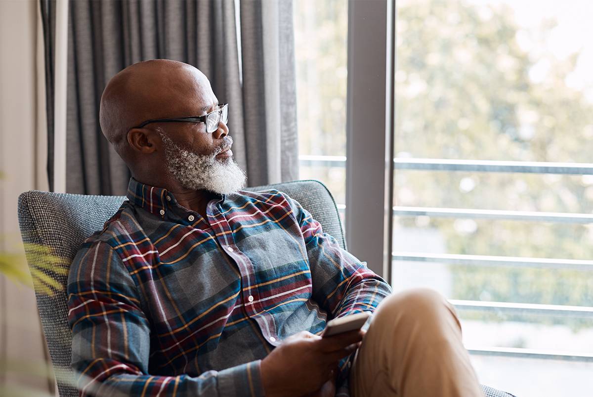 Senior man looking out a window