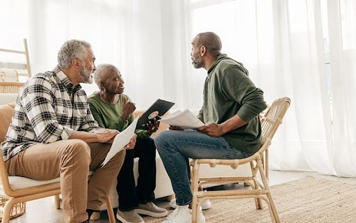 Mature man going through paperwork on the meeting with senior couple