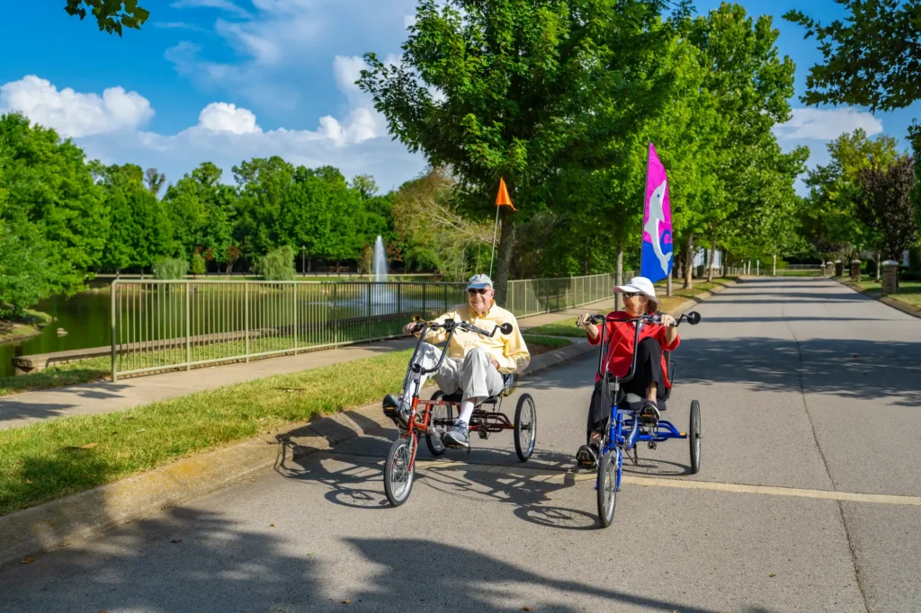 The Heritage residents have fun outdoors while cycling at a local park.