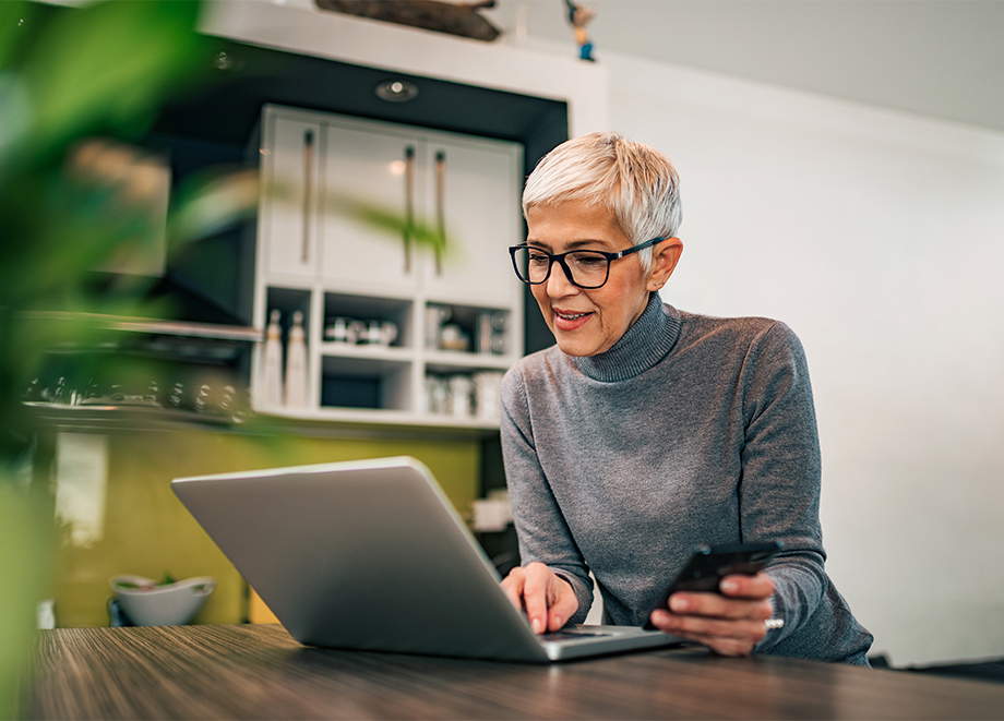 senior woman uses her computer to research senior living