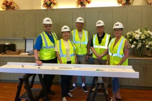 People in hardhats posing in front of a table