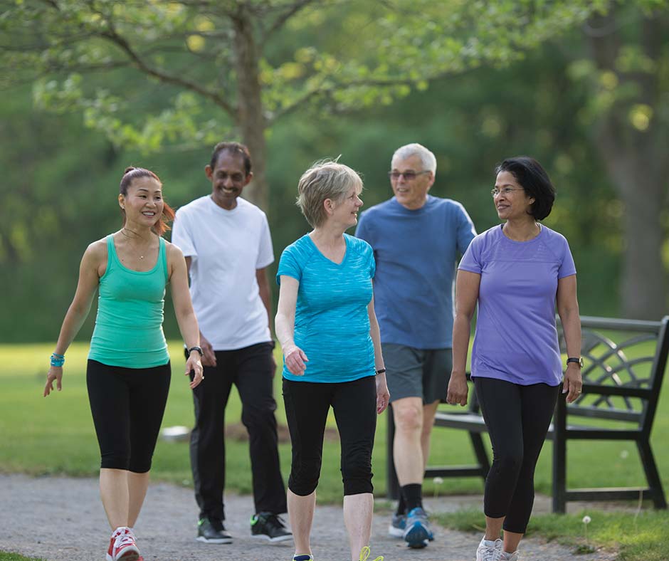 A group of seniors in fitness gear going on a walk on the trails at Brentwood