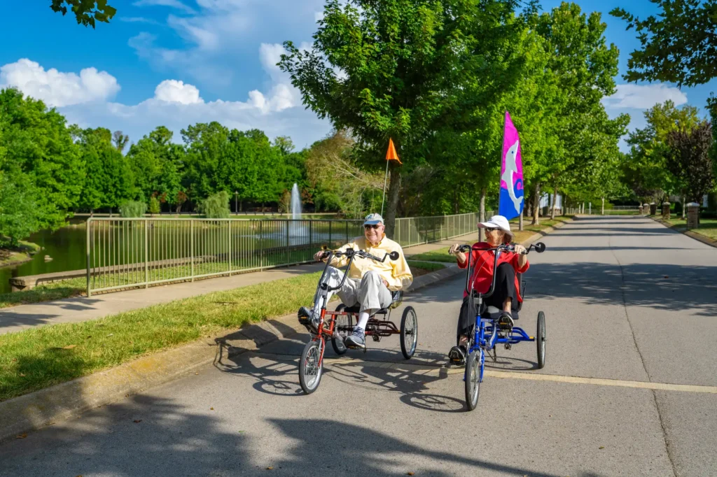 The Heritage residents have fun outdoors while cycling at a local park.