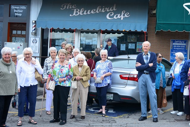 A group of seniors posing in front of The Bluebird Cafe