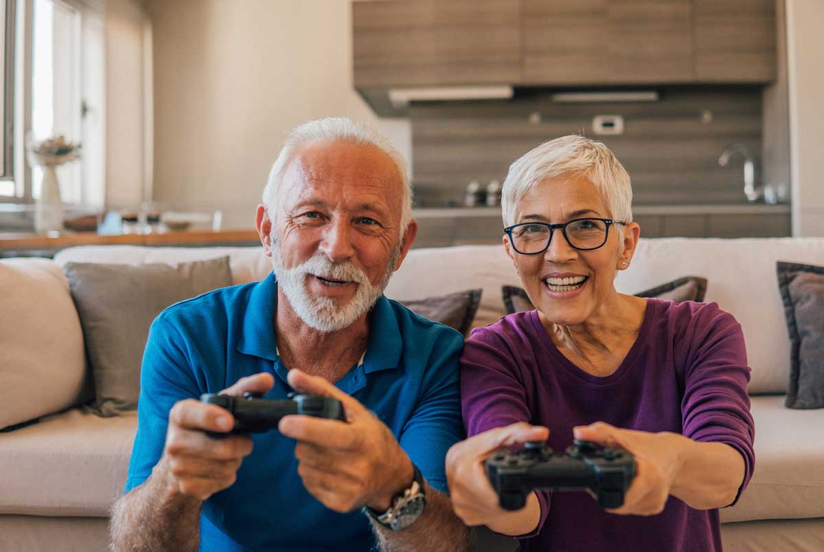 two seniors happily play video games in their senior living facility