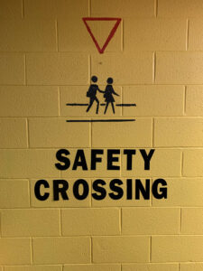 "Safety Crossing" painted on a yellow wall
