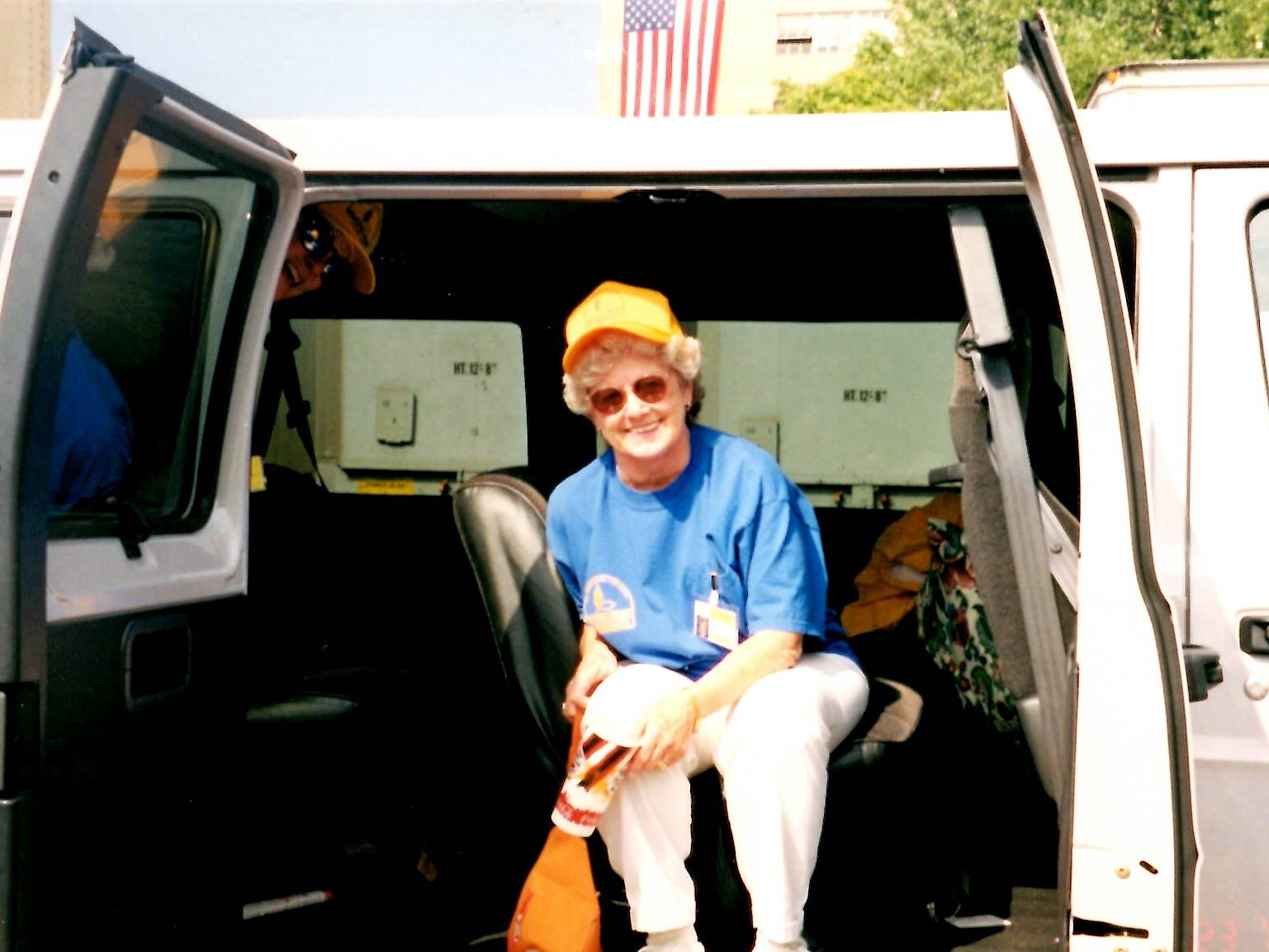Senior woman in yellow hat sitting in a van