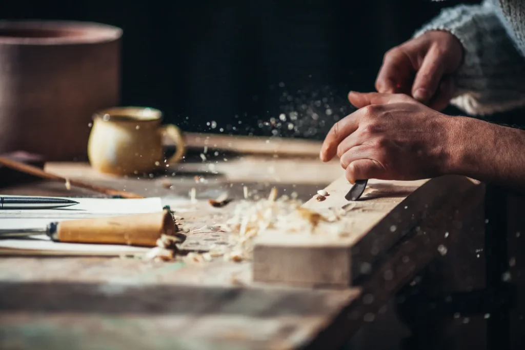 Close up of elderly person's hands carving wood